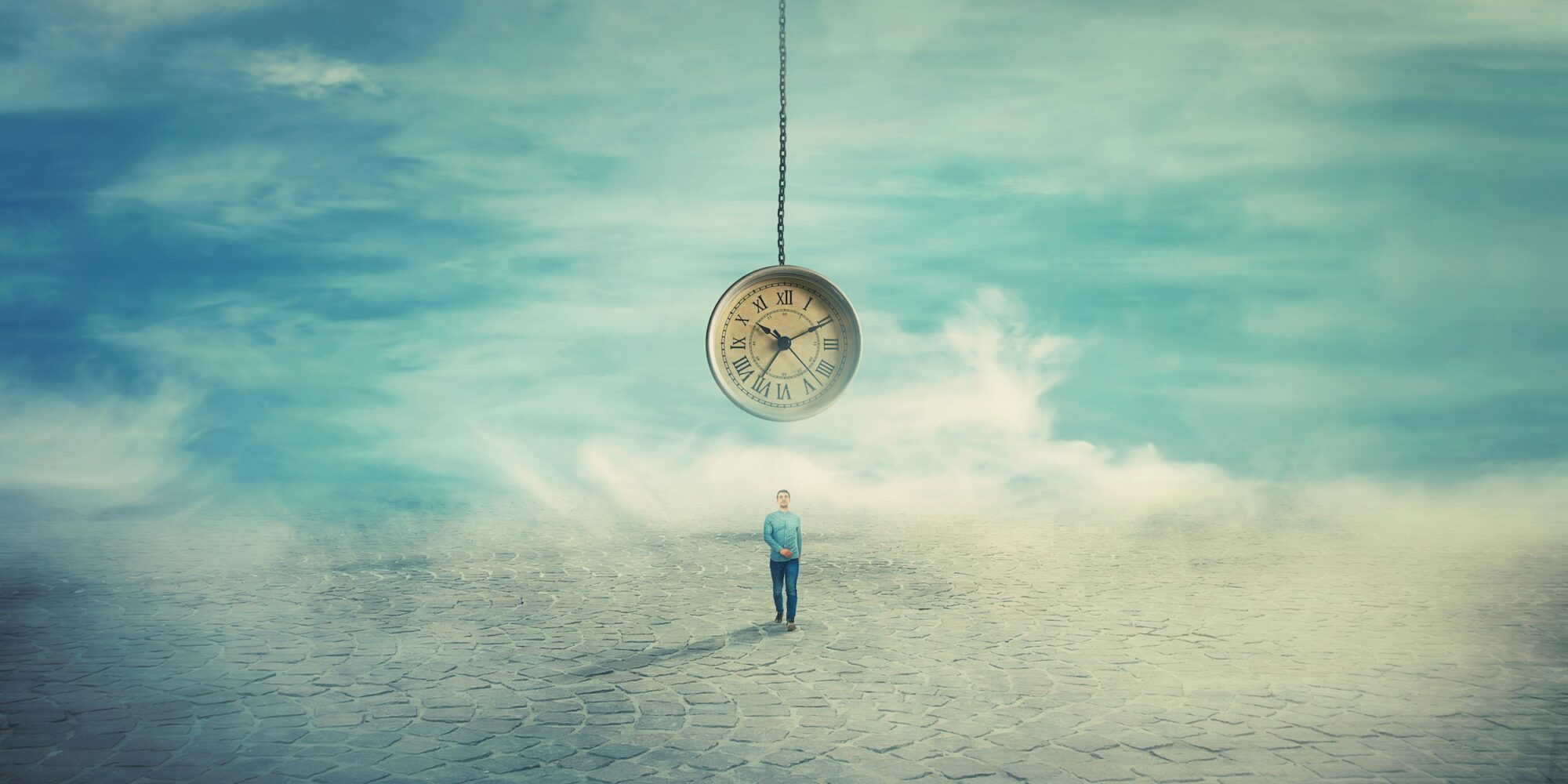 Surreal view as a man walking on a pavement road and a suspended clock on his back hanging from the sky. The importance of time in the modern world. Time travel concept.